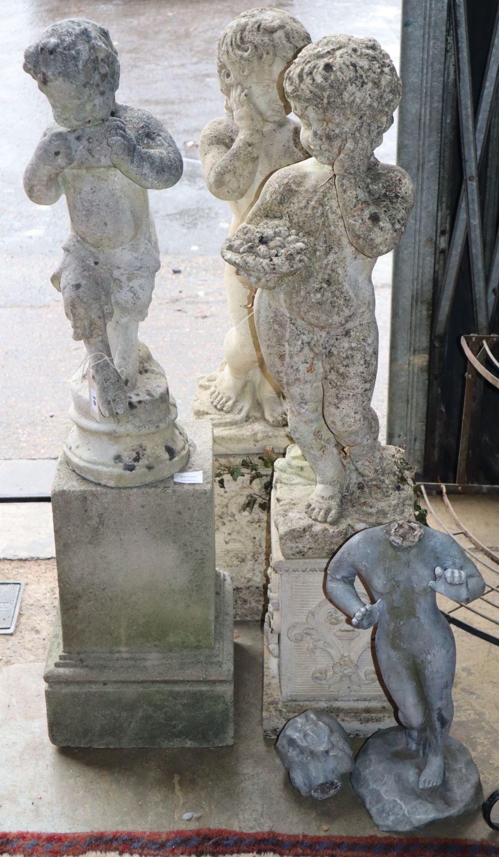 A lead garden ornament and three reconstituted stone figural ornaments, largest 104cm high